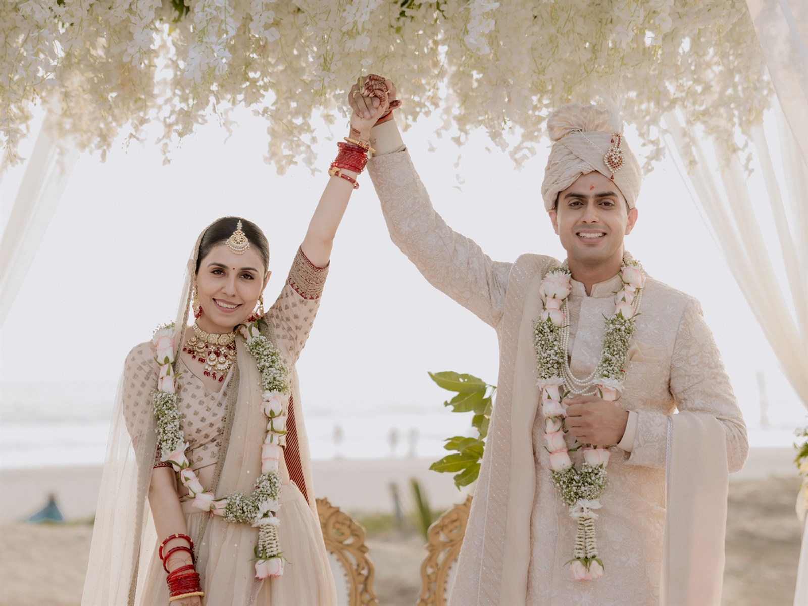 A couple celebrating under a floral mandap on a Goa beach, photographed by White Elefhant Studios
